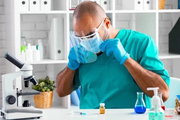 Médecin afro-américain assis à la table et se préparant à faire une injection de drogue — Photo