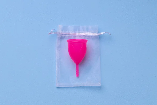 Puchar menstruacyjny na niebieskim tle widok z góry — Zdjęcie stockowe