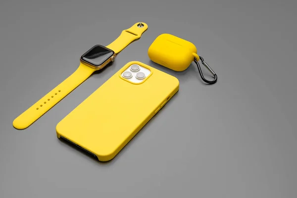 Smartphone jaune, smartwatch et écouteurs sur fond gris — Photo