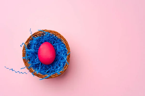 Œuf de Pâques rose dans un nid sur fond rose — Photo