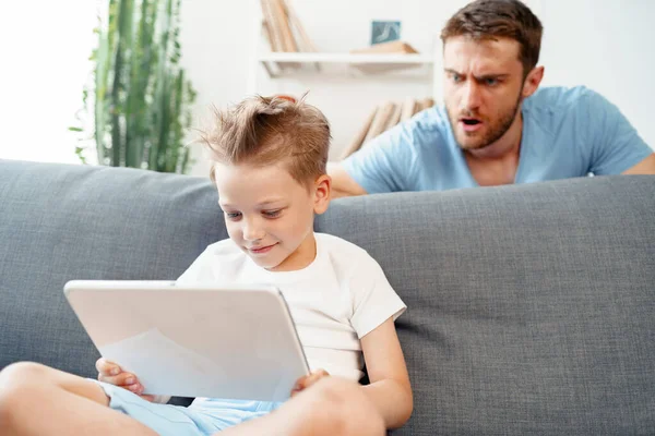 Padre preocupado mirando lo que su hijo está viendo en la tableta digital — Foto de Stock