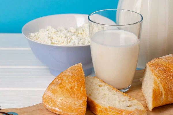 Üvegedény tej, tál túró és kenyér fából készült asztalon — Stock Fotó