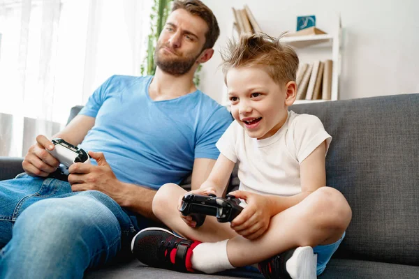 父と息子はビデオゲームを一緒に家で — ストック写真