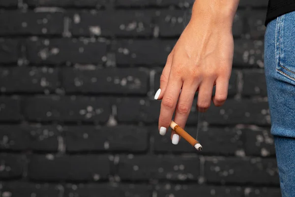 Ženská ruka drží zapálenou cigaretu zblízka — Stock fotografie