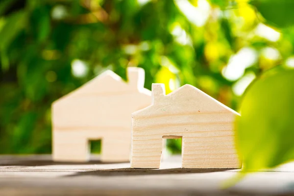 Jouet maison en bois sur table en bois sur fond de feuillage — Photo