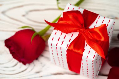 Sevgililer günü hediyesi ve ahşap masada gül.