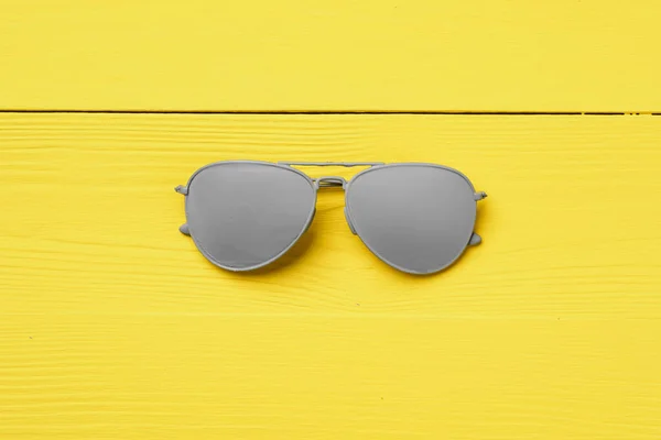 Серые солнечные очки на желтом фоне — стоковое фото