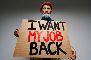 Pankart. İşimi geri istiyorum. Maskeli bir protestocunun ellerine..