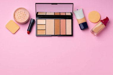 Pembe arka planda yüz rengi için kozmetik ürünler