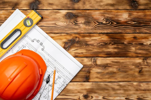 建設労働者のハードハット、設計図と.constructionレベル、トップビュー — ストック写真