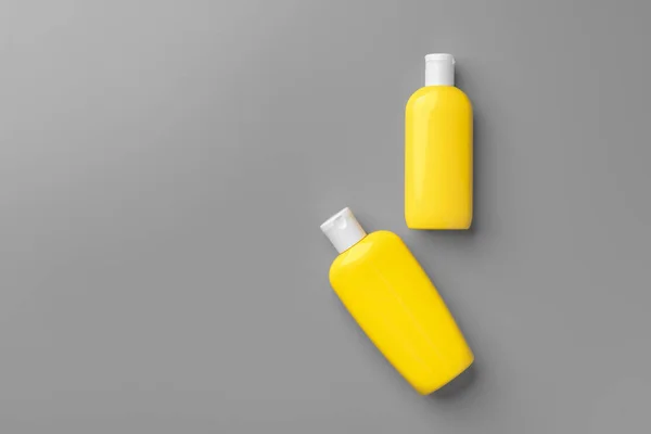 Gelbe Kosmetikbehälter auf grauem Hintergrund von oben — Stockfoto