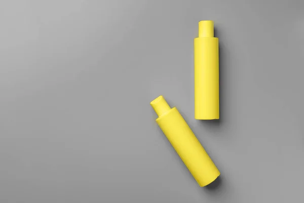 Yellow cosmetic container on gray background top view — Stock Photo, Image