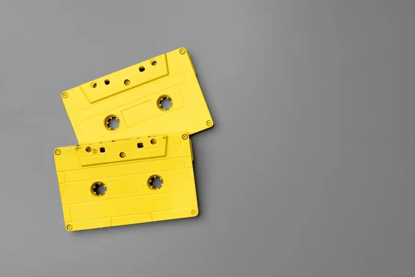 Gelbe Audiokassetten auf grauem Hintergrund von oben — Stockfoto