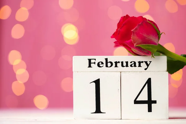 Calendario de madera 14 de febrero sobre fondo rosa bokeh — Foto de Stock