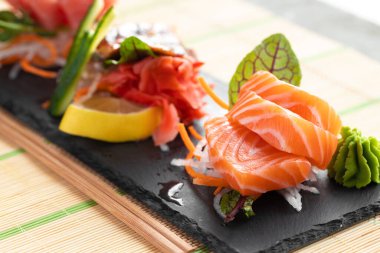 Somon, yılan balığı ve ton balıklı saşimi suşi tabakta servis edilir.