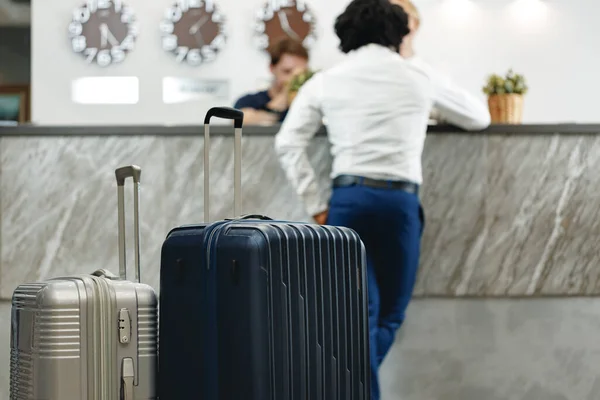 Oigenkännlig affärsman stående med bagage resväska i hotellets lobby — Stockfoto