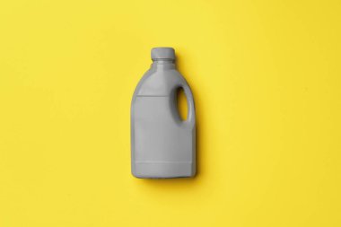 Sarı arka planda gri sıvı deterjan kabı