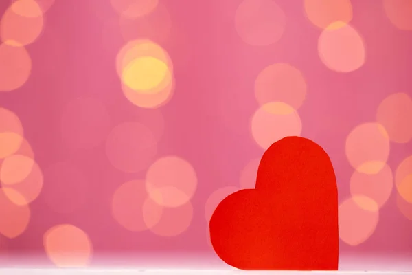 Decoración de corazón rojo contra fondo rosa bokeh — Foto de Stock