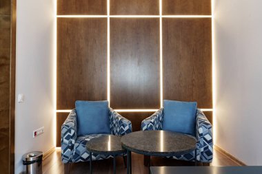 Kol sandalyesi ve sehpası olan ofis bekleme salonu.