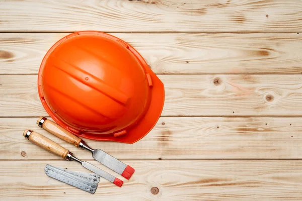 Byggarbetare verktyg hårdhatt och mejsel på trä bakgrund — Stockfoto