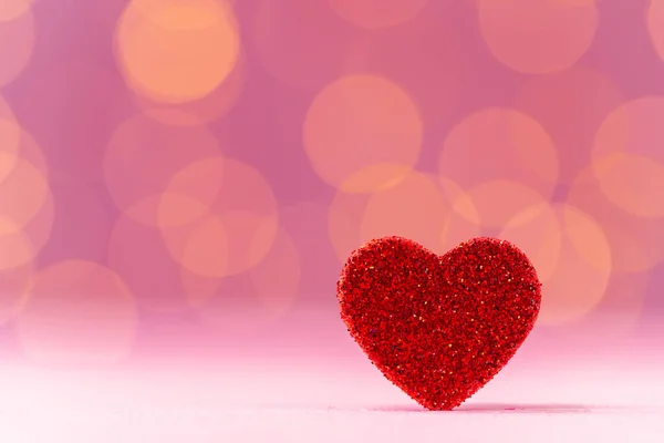 Decoración de corazón rojo contra fondo rosa bokeh — Foto de Stock