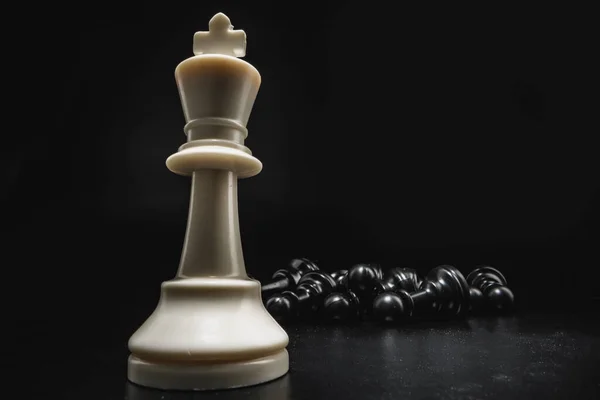 Schaken spel met schaakstukken tegen zwarte achtergrond — Stockfoto