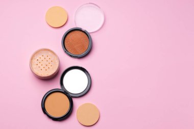 Pembe arka planda yüz rengi için kozmetik ürünler