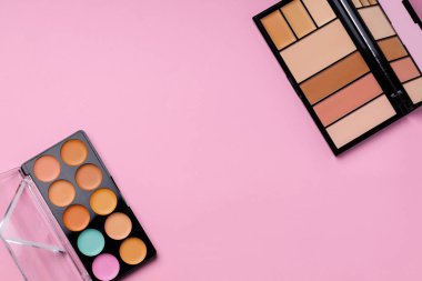 Pembe arka planda yüz rengi için kozmetik ürünler