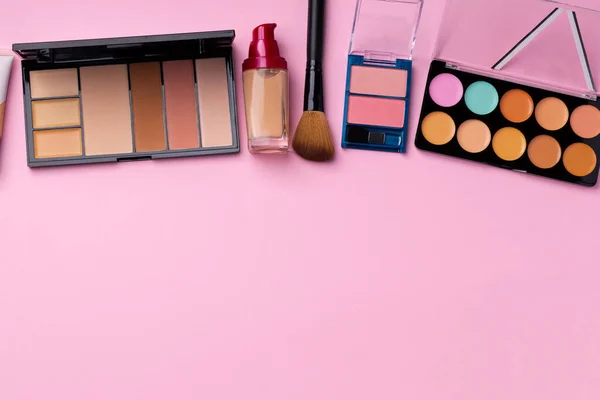 Make-up-Produkte für den Teint und Pinsel auf rosa Hintergrund — Stockfoto