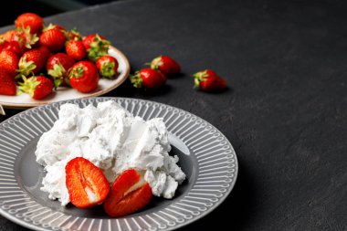 Krem peynir ve siyah arka planda taze çilek.