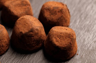 Siyah yüzeyde çikolatalı trüf şekeri. Yaklaş.