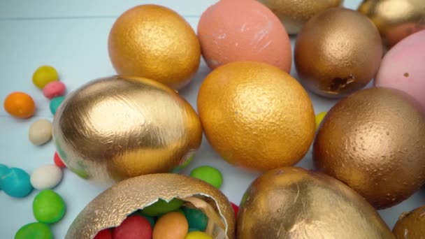 부활절 달걀을 가까이에 있는 푸른 나무 탁자 위에 금빛으로 칠하는 모습 — 비디오