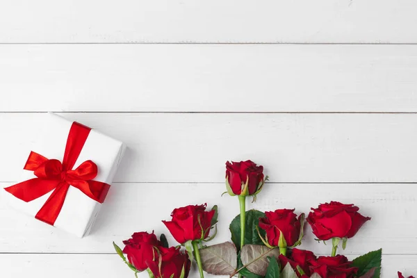 St. Valentines Day. Red roses and gift box on wooden table — Stock Photo, Image