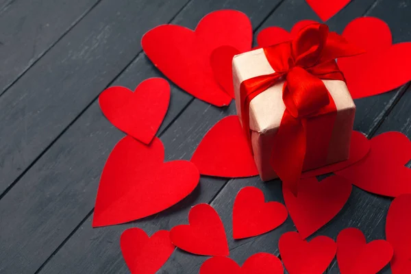 Cadeaudoosje met rode hartjes op houten tafel — Stockfoto