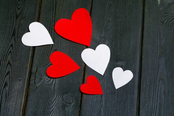 Papel rojo corazones medios amor poner en viejo madera —  Fotos de Stock
