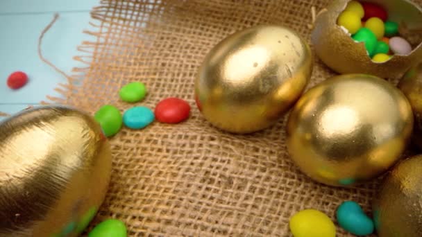 Uova di Pasqua dipinte in colore oro su tavolo di legno blu da vicino — Video Stock