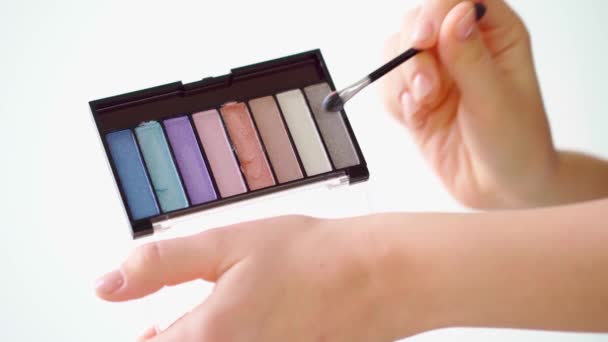 Female hands applying eyeshadows on palm close up — Stock Video