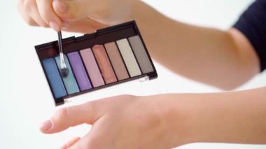 Avuç içlerine göz farı süren kadın eller.