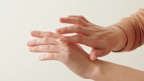 Femme appliquant crème pour les mains sur fond blanc fermer — Video