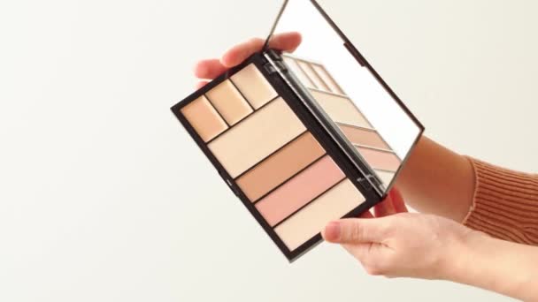 Female hands presenting make up palette with face foundation — Stock Video