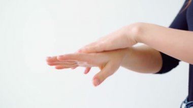 Beyaz arka plana el kremi süren kadın.