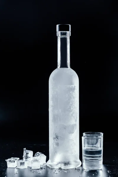 Botella de vodka frío sobre fondo oscuro — Foto de Stock