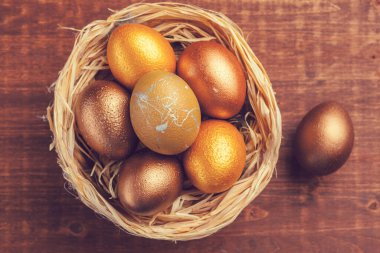 Ahşap arka planda altın Paskalya yumurtaları