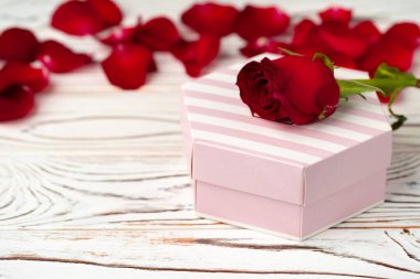 Sevgililer günü hediyesi ve ahşap masada gül.