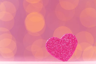 Pembe arka planda pembe pırıltılı kalp dekorasyonu
