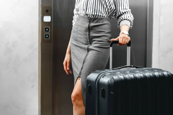 Nierozpoznawalna bizneswoman stojąca z torbą podróżną blisko — Zdjęcie stockowe