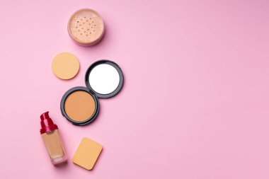Pembe arka planda yüz rengi için kozmetik ürünler