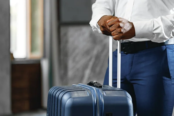 Hombre de negocios irreconocible parado con maleta de equipaje en el vestíbulo del hotel — Foto de Stock