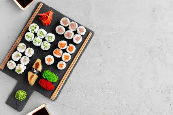 Maki sushi set geserveerd op zwarte stenen dienblad — Stockfoto