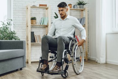 Resmi olarak tekerlekli sandalyede oturan engelli bir adamın portresi.